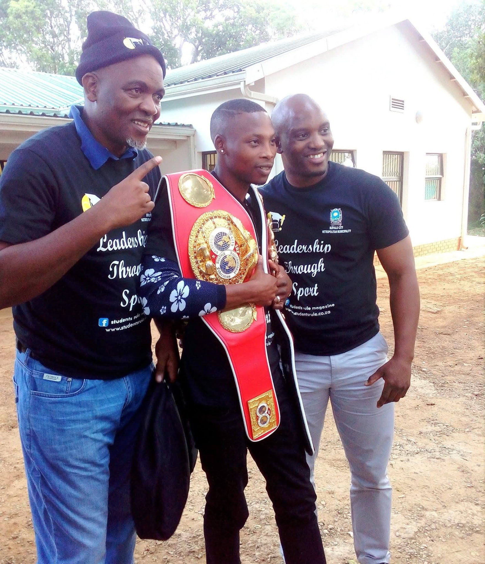 Zolani Tete holding his championship belt with Students Rule Movement leaders