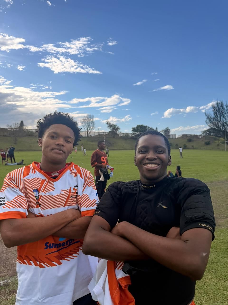 Two Olutsha Wolves players smiling after a match in Summerpride kit